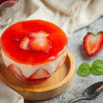 Homemade yogurt with fresh strawberry on old dark background